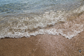 Sea foam beats on the sandy shore