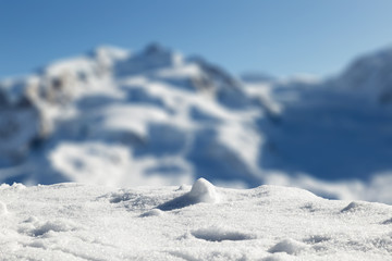 Foreground with fresh snow, with Swiss mountains in the blurred background.