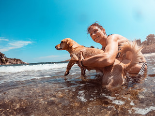 Woman taking her dog to swim in the sea