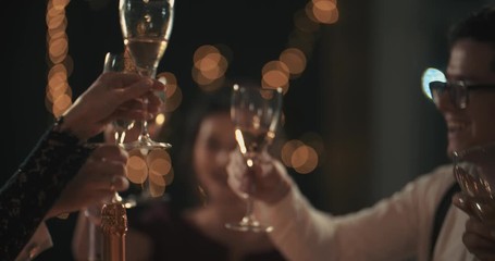Multiracial young mans and womans wearing fashion wear clinking glasses with champagne, happy asian american and caucasian friends celebrating xmas, new year or birthday party indoors - Powered by Adobe