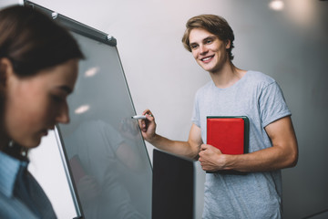Happy Caucasian male mentor explaining information for using with startup project standing in...