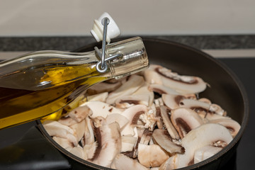 Oil über Pilze im Topf giessen