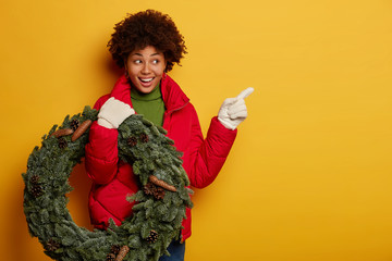 Look here, I have something interesting and awesome for you. Positive Afro female in red jacket,...