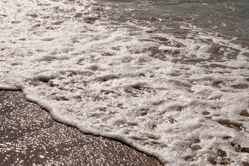 Black Sea. Water with waves. Mainly cloudy weather and sun rays. Blue and grey clouds. Before rain. Sand coast