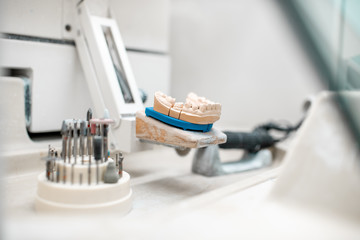 Artificial jaw for implants modeling with set of dental burs at the working place of dental...