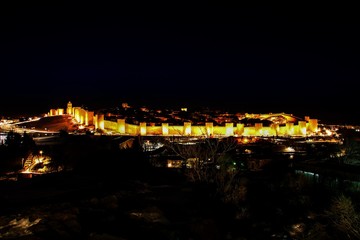 Fototapeta na wymiar Ávila al anochecer con su muralla medieval iluminada (España).