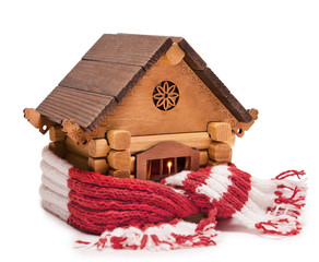 A wooden house wrapped in a warm knitted scarf. Isolated on white background.