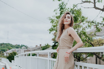 Portrait of a beautiful fashionable woman in a stylish beige dress