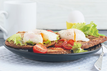 Appetizing snack of sandwiches with poached egg and vegetables