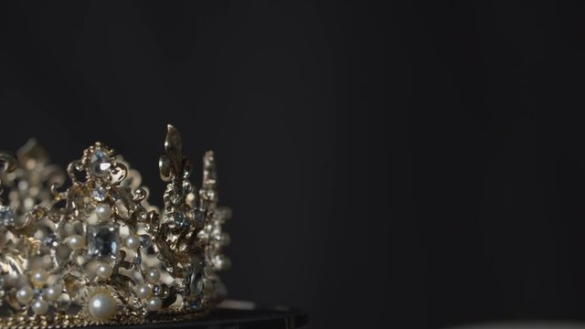 Amazing valuable crown for a royal queen, bride or beauty pageant winner on display on a turntable stand with copy space