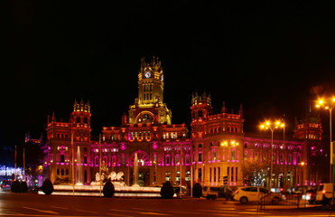 Fuente de Cibeles y fachada del palacio de Cibeles iluminados de noche en Madrid, capital de...
