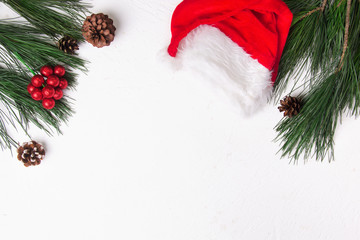 Christmas background with fir and santa hat on white background. Flat lay. Mockup.