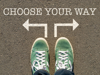 photo on top of the sneakers and the inscription choose your way on the asphalt, the concept of free choice, direction of movement, the philosophical question of life