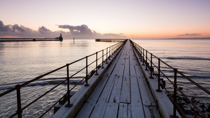 Obraz premium View of Blyth Harbour Piers, Blyth on the coast of Northumberland, England, UK. At sunrise on a winter morning.