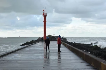 Deurstickers pier with lighthouse and walking people near Hoek van Holland © henkbouwers