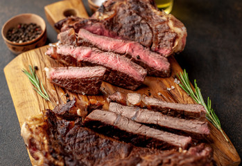 two grilled steaks with spices, with two types of frying on a stone background