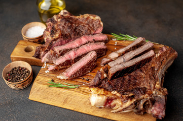 two grilled steaks with spices, with two types of frying on a stone background