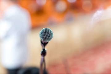 Microphone in concert hall or conference room soft and blur style for background.Microphone over the Abstract blurred photo of conference hall or seminar room background.