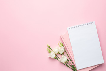 Pink background with beautiful white eustoma flower and notebook . Flatlay with copyspace