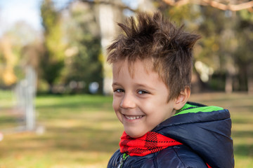 kid with a funny haircut in public park 