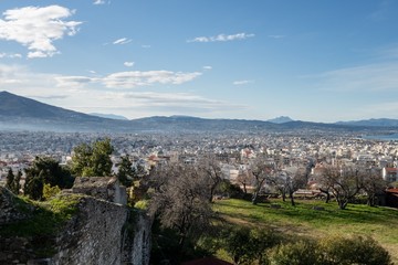 The wall of the medieval Patras Castle in Greece at sunrise with the city
