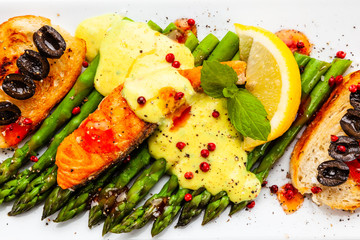 Grilled salmon and asparagus on white background