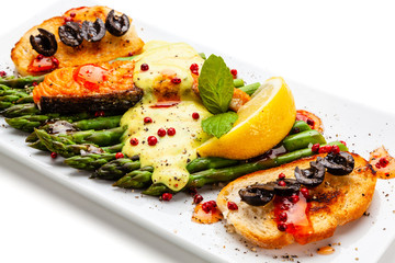 Grilled salmon and asparagus on white background