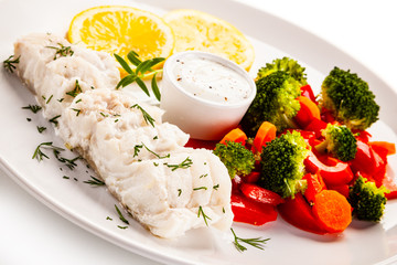 Fish dish - fried fish fillet with vegetables on white background