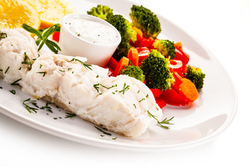 Fish dish - fried fish fillet with vegetables on white background