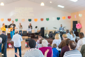 Children on stage perform in front of parents. Parents watch children's performances. Children's holiday