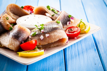 Marinated herring fillets on wooden table
