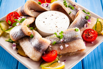Marinated herring fillets on wooden table