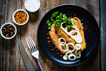 Fish dish - marinated fried fish fillet on wooden table