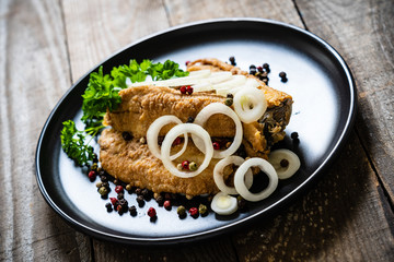 Fish dish - marinated fried fish fillet on wooden table