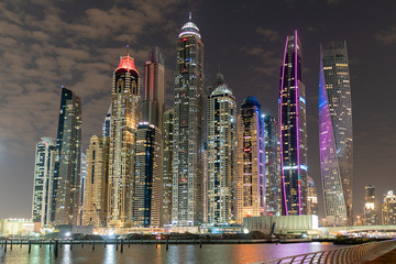 Dubai skyline at night with lights on the water and luxirious skyscrapers of UAE	