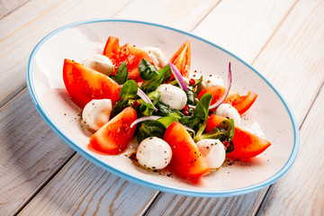 Caprese salad on wooden table