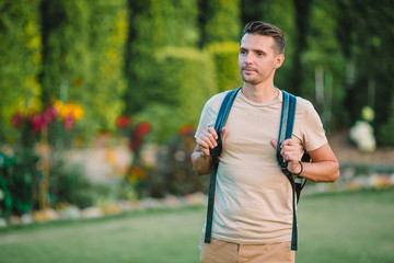 Fototapeta premium Young man hiking smiling happy portrait. Male hiker walking in the city