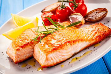 Grilled salmon with vegetables on white plate