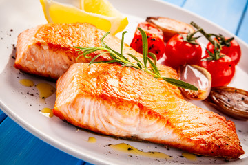 Grilled salmon with vegetables on white plate