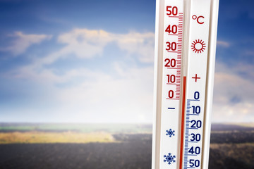 The thermometer on the background of the field shows 15 degrees of heat_