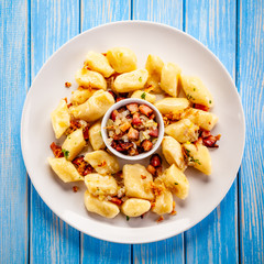 Potato noodles - dumplings on wooden background