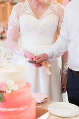 Bride and groom cut the wedding cake with Roses