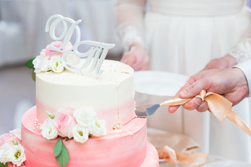 Bride and groom cut the wedding cake with Roses