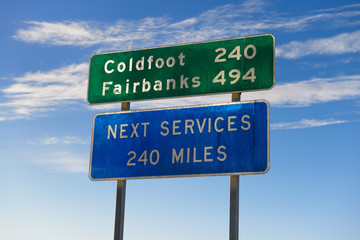 Signs in Deadhorse Alaska for Coldfoot and Fairbanks indicating one service station on the Dalton Highway