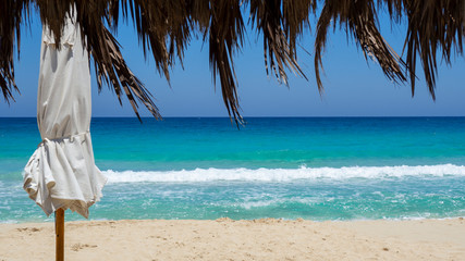 Marsa Matruh, Egypt. The sandy beach and the amazing sea with tropical blue, turquoise and green colors. View through a gazebo. Relaxing context. Fabulous holidays. Mediterranean Sea