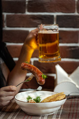 Girl dines in a pub fried sausages