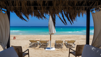 Marsa Matruh, Egypt. Elegant gazebo on the beach. Amazing sea with tropical blue, turquoise and green colors. Relaxing context. Nobody on the beach. Fabulous holidays. Mediterranean Sea. North Africa