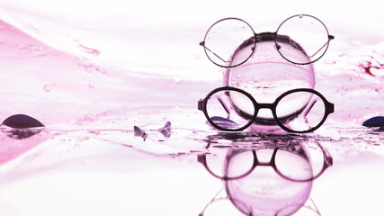 Tools for vision correction. Glasses and lenses with diopters on the background of splashes and...