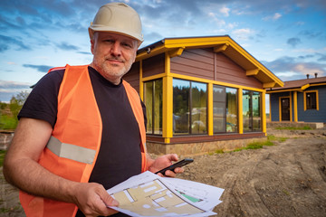 Architect at the construction site. Call to the architect. Builder is looking at the blueprints....