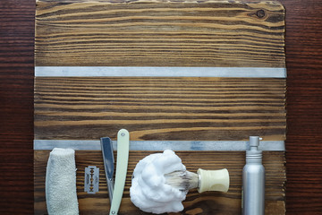 Fototapeta na wymiar Shaving accessories on a wooden texture background. Tools. Disposable shaving machine, brush, foam and hazard razor.